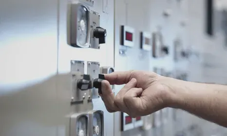 Hand switching knobs on a large electrical board
